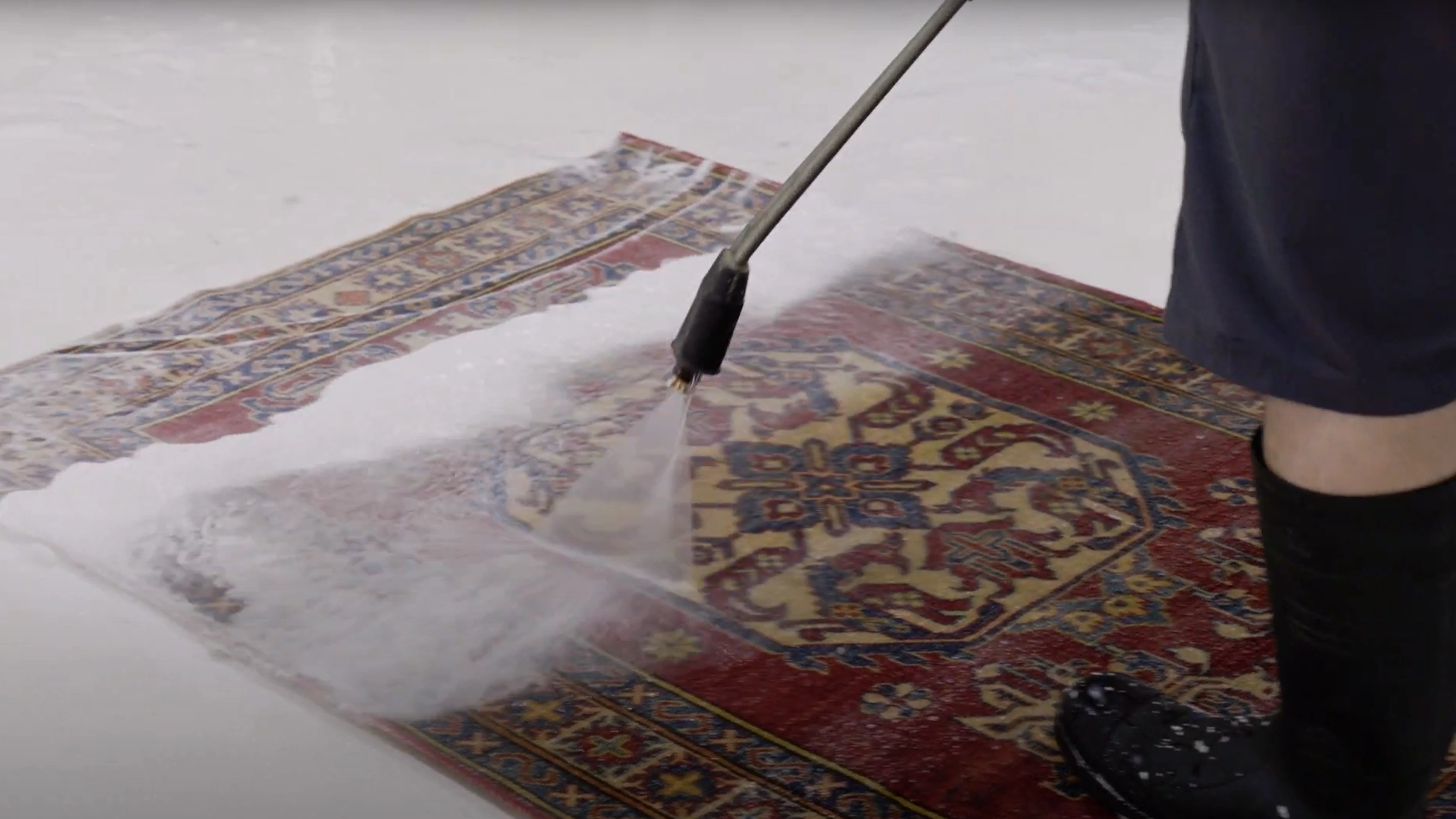 Deep hand washing a rug with water pressure at Rug Life